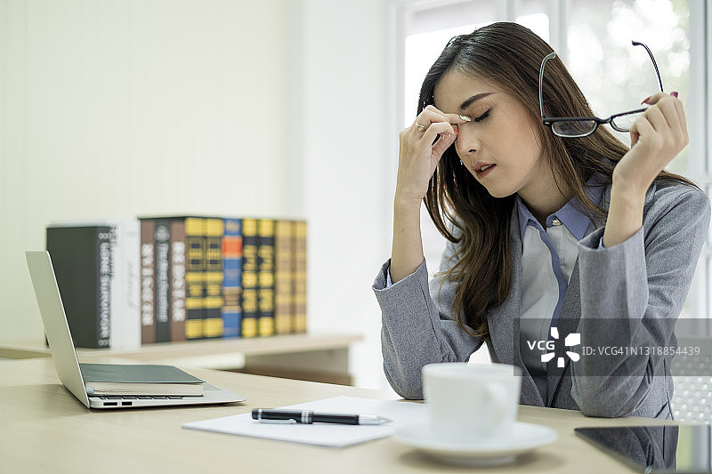 在现代办公室工作时，因压力而痛苦的年轻女子图片素材