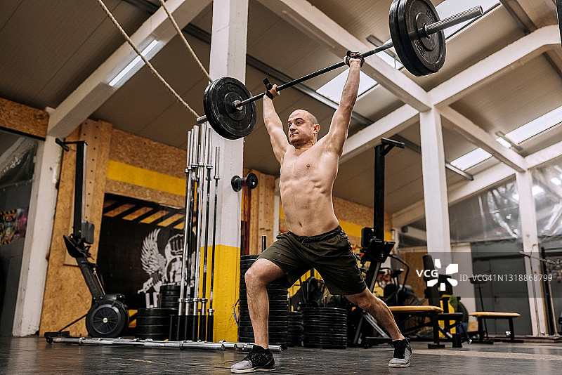 健壮的男人在健身房举杠铃图片素材