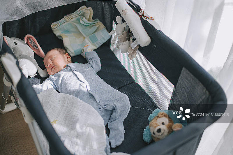 俯视视角：在婴儿床里睡觉的亚洲华裔男婴图片素材