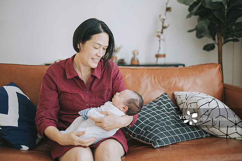 中国奶奶在客厅沙发上抱着孙子的肖像图片素材