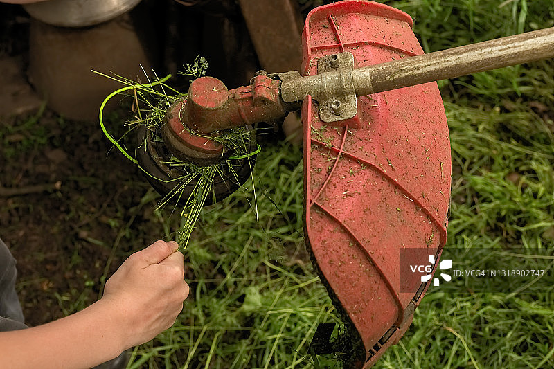 清理割草机上的草屑特写图片素材
