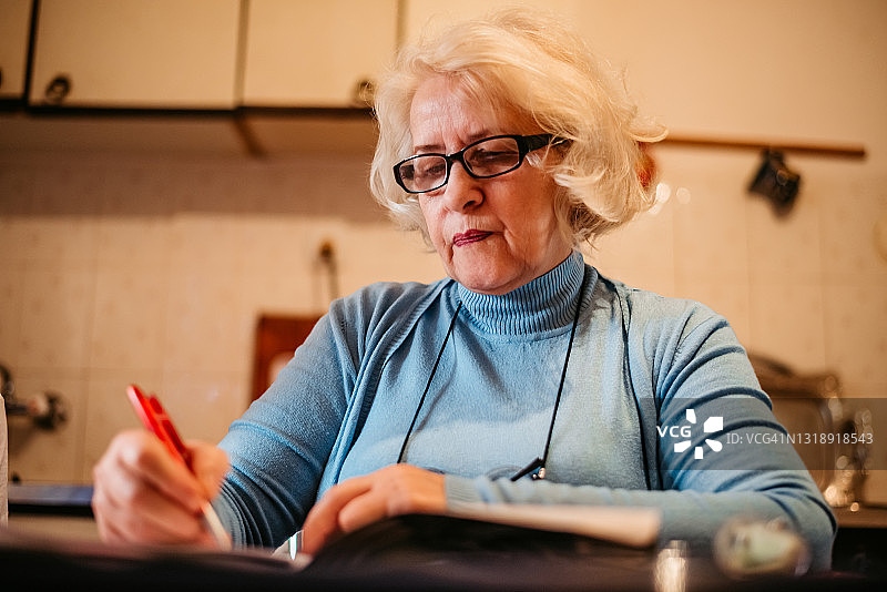 老年妇女写日记或书图片素材