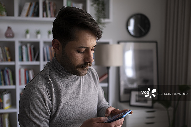 办公室职员在窗边使用智能手机图片素材