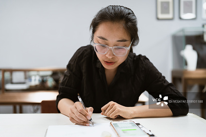 亚洲女设计师根据客户需求进行设计图片素材