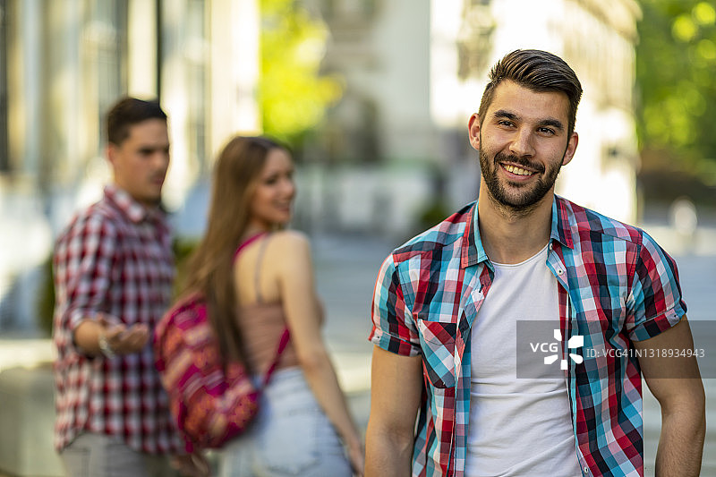不忠的年轻女人看着另一个男人，她愤怒的男朋友在街上看着她图片素材