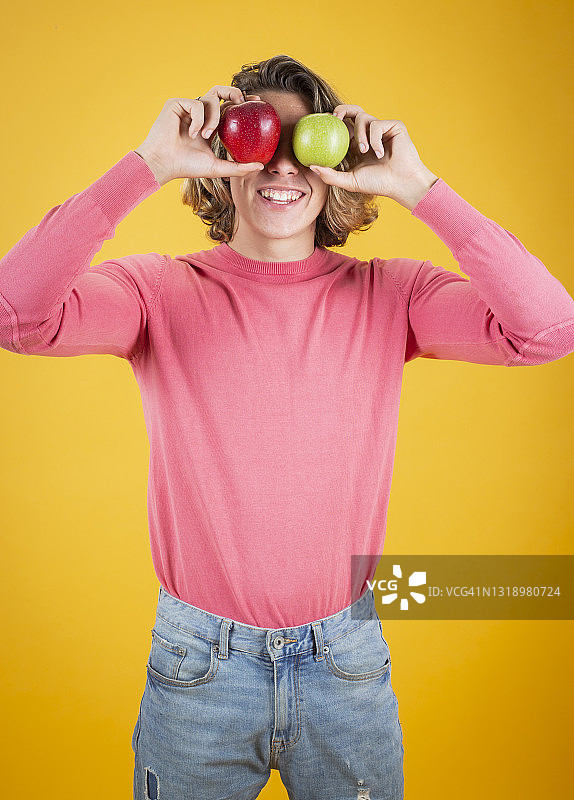 拿着红色和绿色苹果的快乐男人图片素材