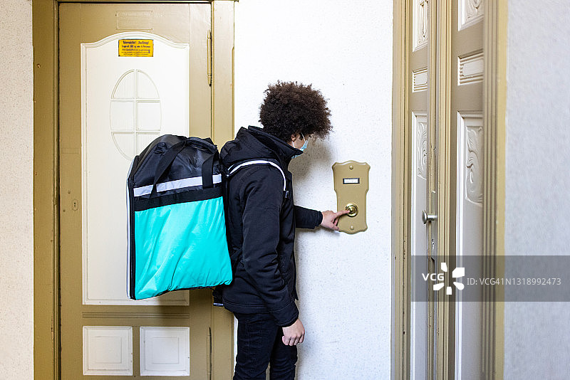 外卖配送员按公寓门铃图片素材