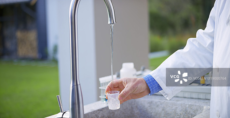 男生物学家用烧杯收集自来水图片素材