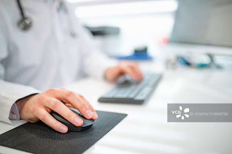 手握电脑鼠标，医生使用现代科技工作图片素材