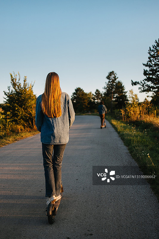 女人在乡间小路上骑着摩托车图片素材