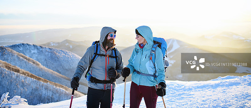 情侣在冬季的自然中徒步旅行，交谈图片素材