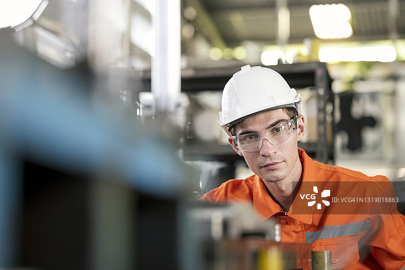 质量控制技术员用游标卡尺检验原材料或工程零件原型，并与工厂的质量标准检查表进行比较。生产过程中的质量控制。图片素材