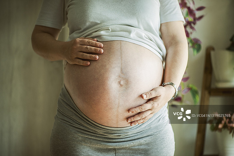 孕妇手托腹部特写图片素材