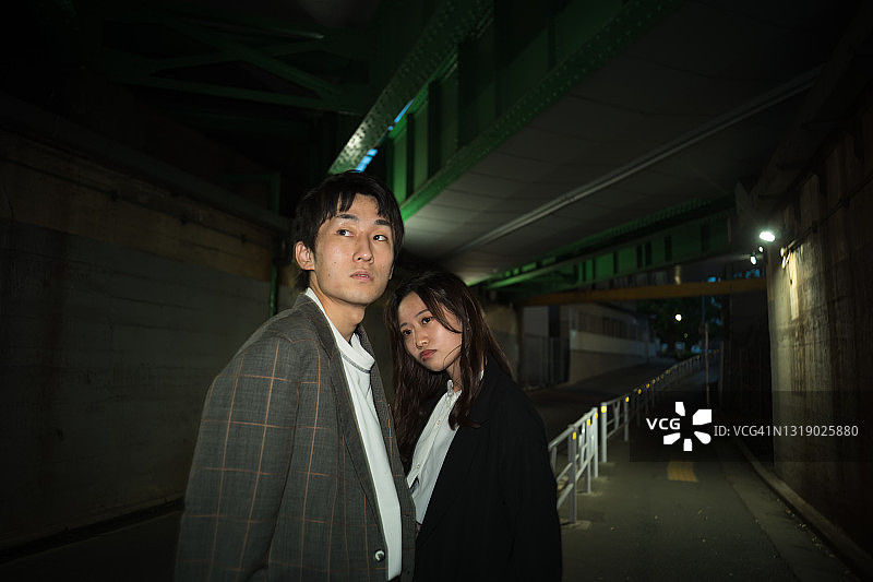 日本年轻夫妇在昏暗通道中的严肃肖像图片素材