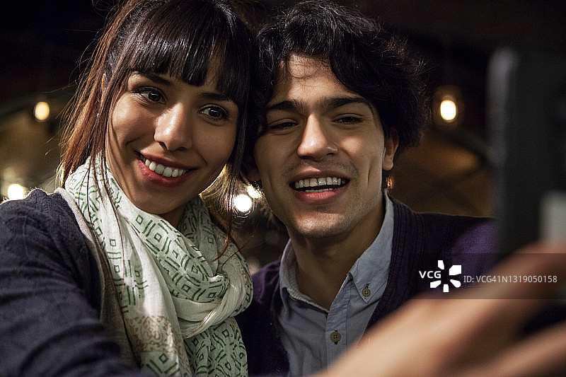 快乐的朋友们在夜晚的酒吧自拍图片素材