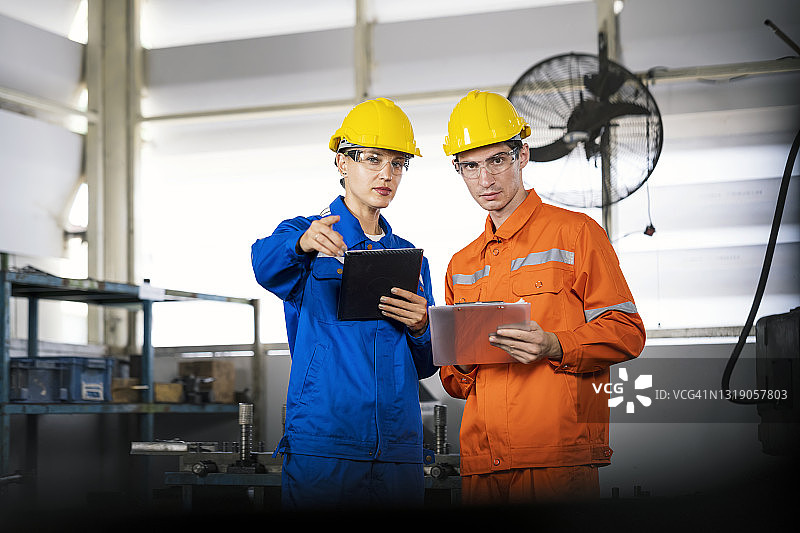 女经理和生产工程师在工厂车间开会讨论新产品开发流程图片素材