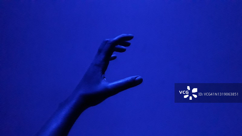 蓝色光晕下的手部姿势图片素材