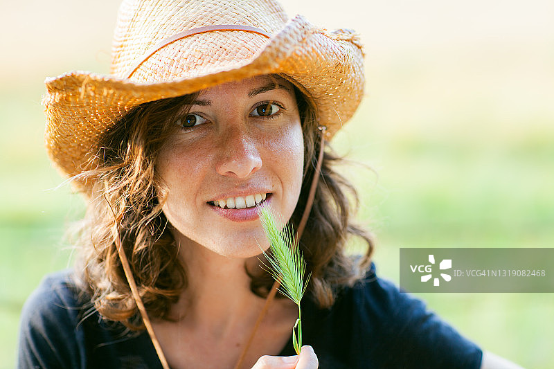 手持绿色小枝的年轻女牛仔图片素材