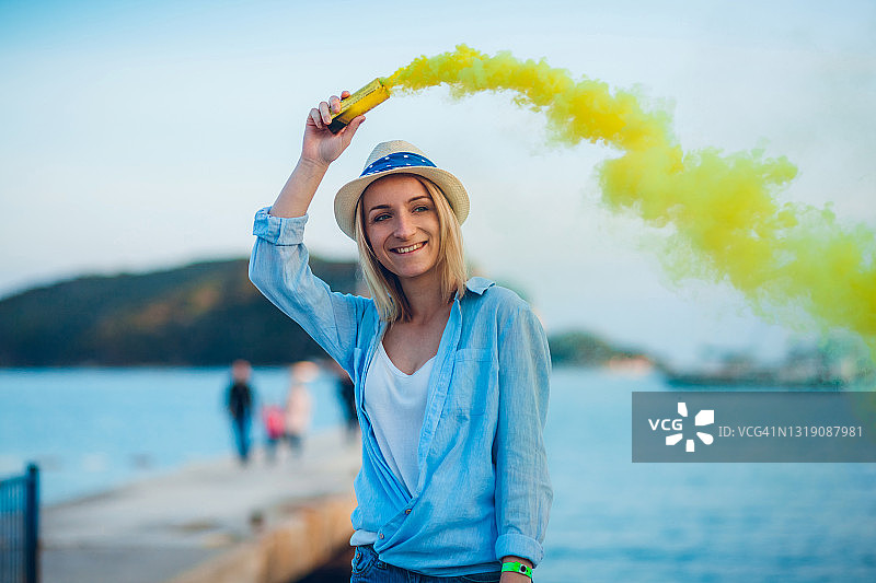 女人在海滩上玩烟雾弹，非常开心图片素材