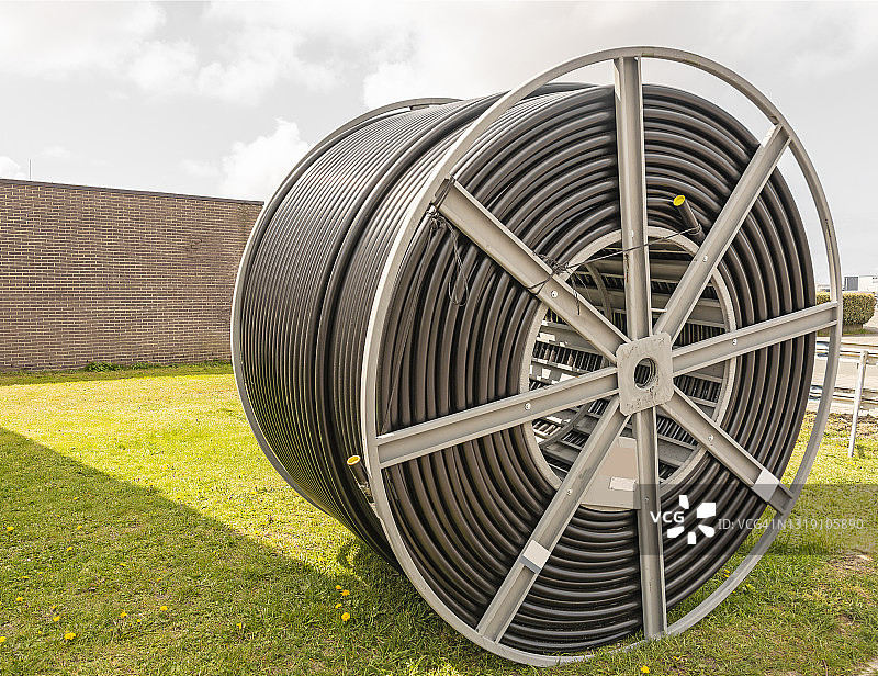 包含盘绕塑料软管的大型金属电缆卷筒图片素材
