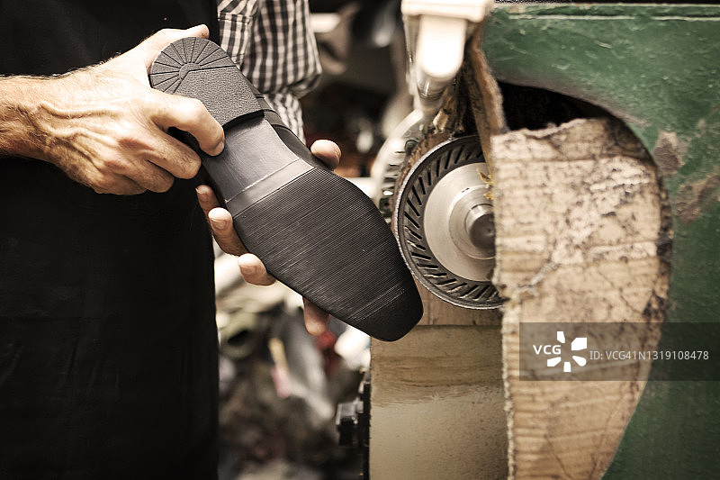 鞋匠在车间用机器打磨鞋子图片素材