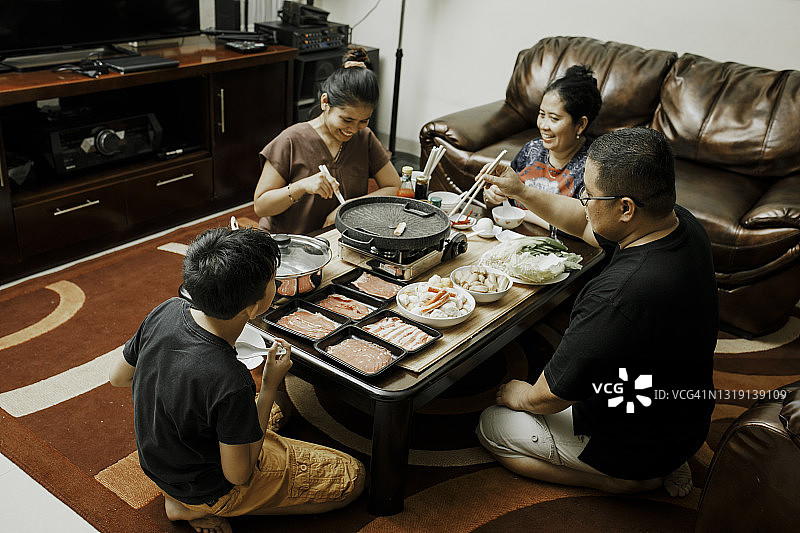 快乐的亚洲家庭在餐桌上共进午餐图片素材