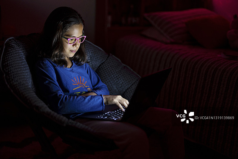 夜晚使用电脑的青少年女孩图片素材