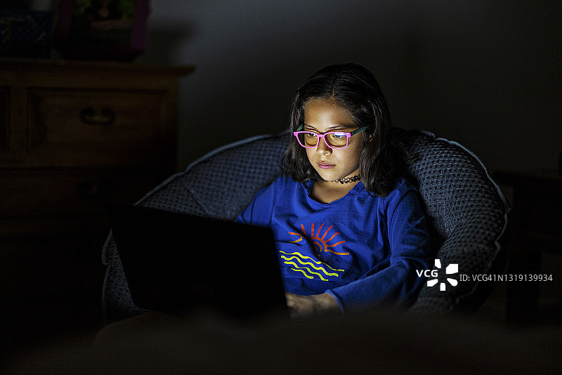 夜晚使用电脑的青少年女孩图片素材