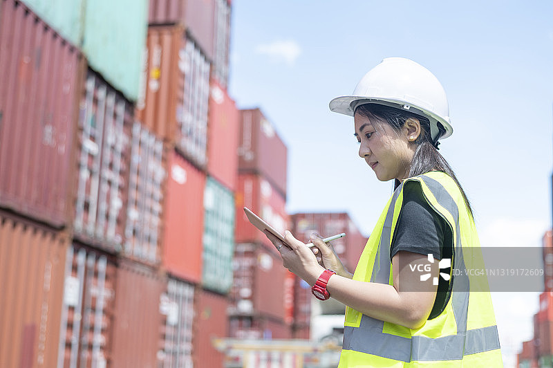 女人在集装箱堆场使用平板电脑工作图片素材