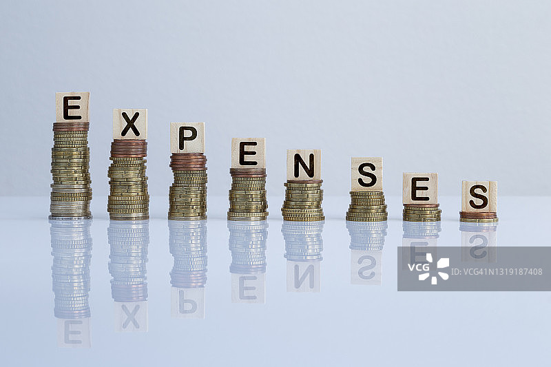 灰色背景上硬币堆叠及木块单词“费用”图片素材