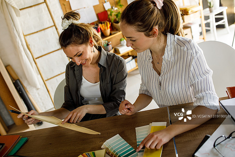 两位女性设计专业人士在审查图纸图片素材