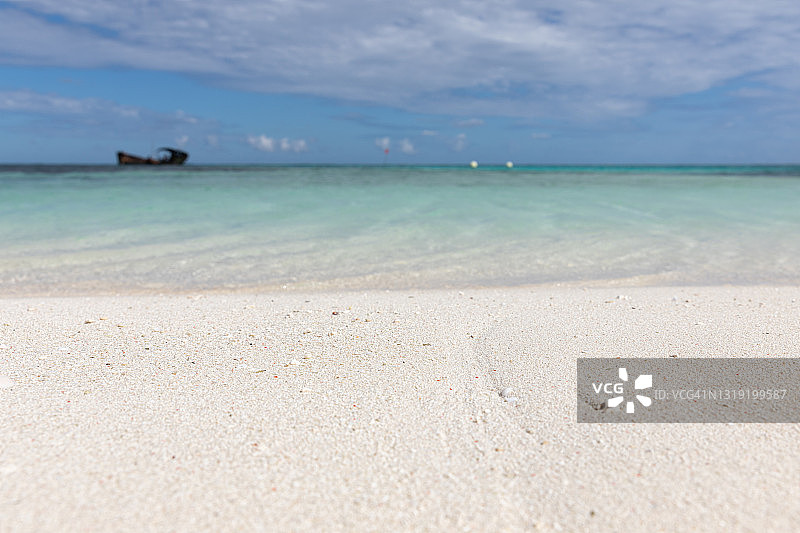 从海岛沙滩上远眺地平线上的沉船残骸图片素材