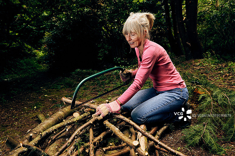 在花园里使用弓锯的女人图片素材