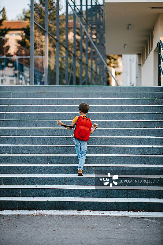 男学生爬楼梯走向学校图片素材