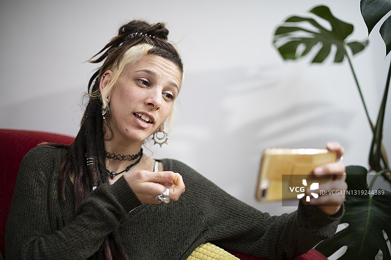 风格独特的年轻女子用手机进行视频会议图片素材