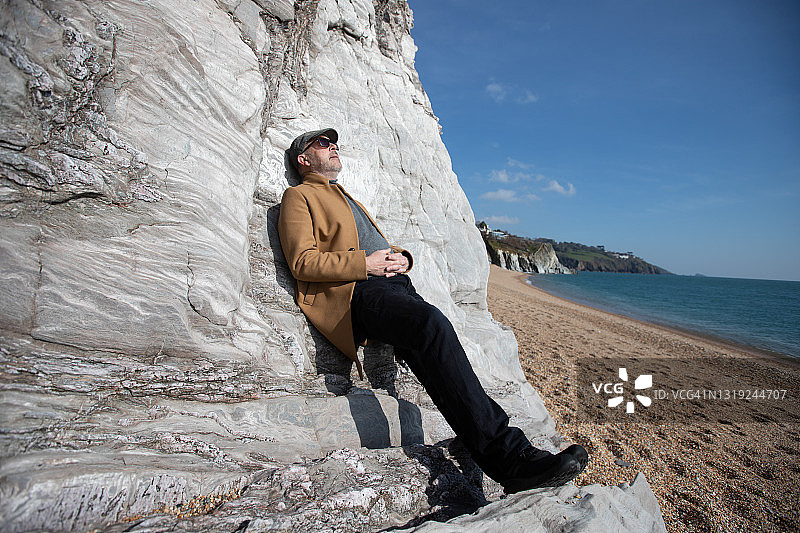男子在德文郡海岸线上放松图片素材