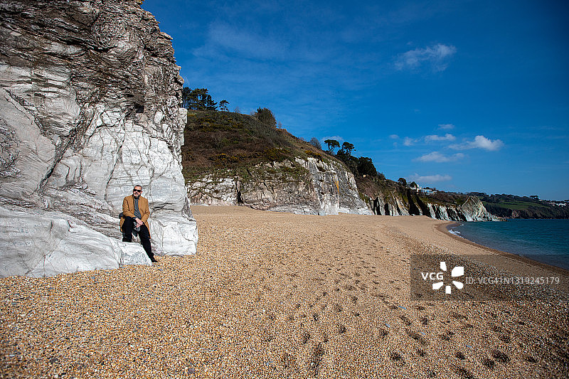男子在德文郡海岸线上放松图片素材