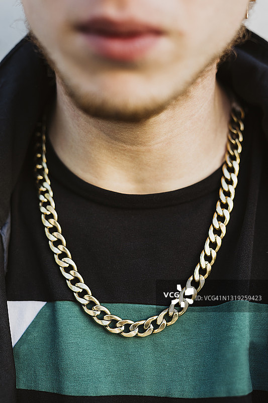 年轻男人脖子上戴着的金色项圈图片素材