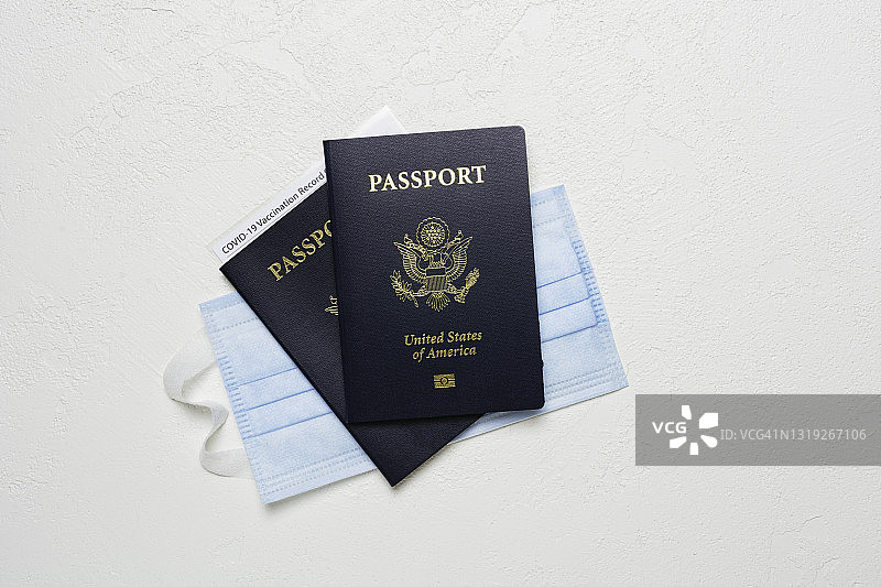 两本美国护照、疫苗接种卡和防护口罩图片素材