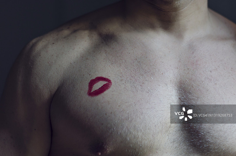 深色背景下胸前有口红印的男人肖像图片素材
