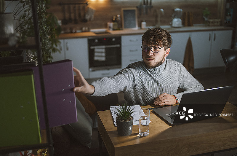 英俊男人晚上在家工作图片素材