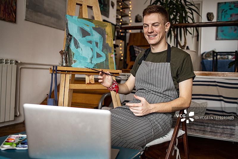 年轻的艺术家正在进行视频通话，展示他的新作品图片素材