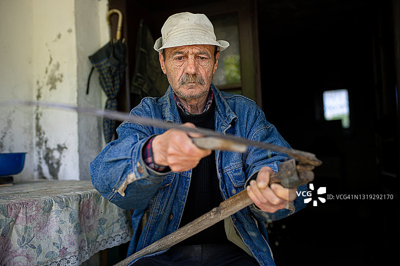 男人磨镰刀图片素材