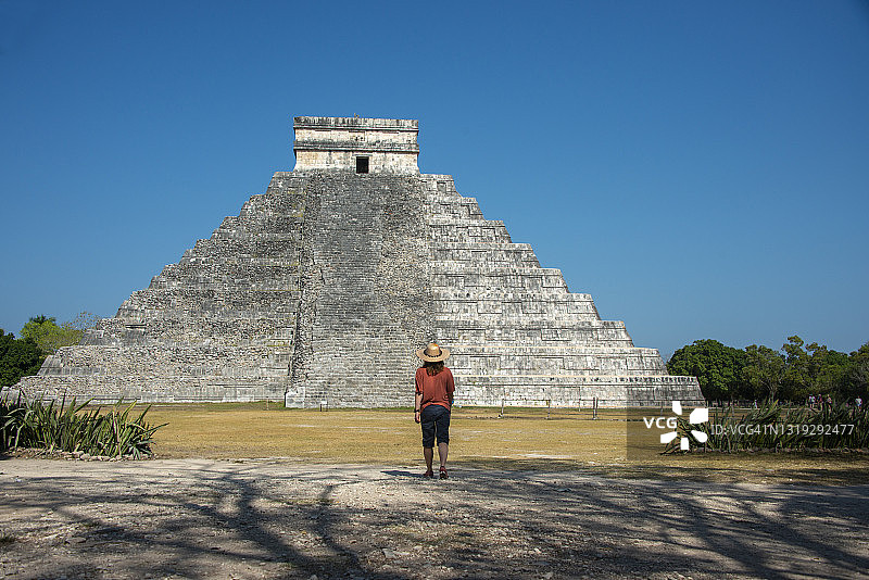 在墨西哥尤卡坦半岛奇琴伊察金字塔前就坐的游客图片素材