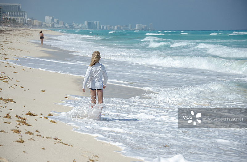 可爱的小男孩在墨西哥坎昆海滩上行走图片素材
