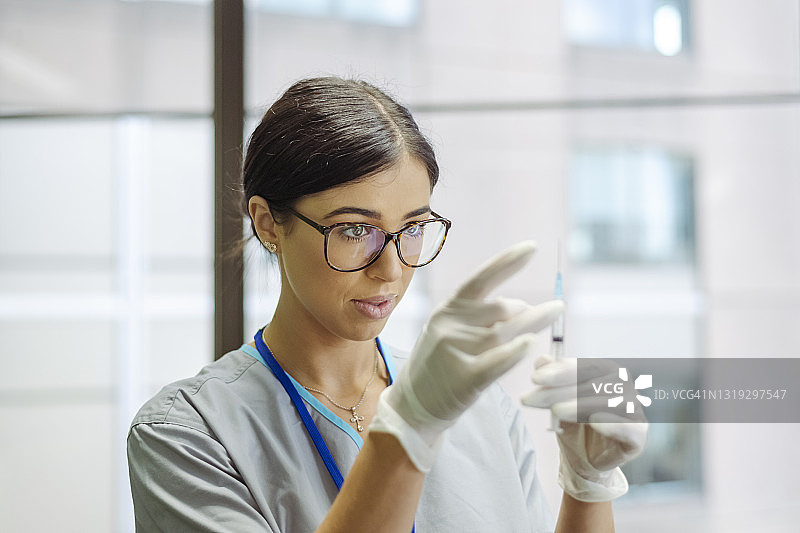 手持疫苗的迷人护士肖像图片素材