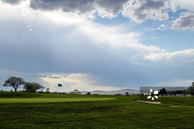 缅因州特纳的春季高尔夫球场与球车上的高尔夫球手图片素材