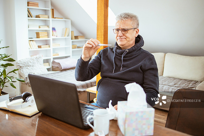 在笔记本电脑前工作的疲惫老人图片素材