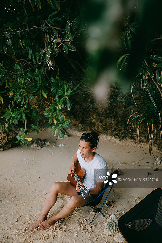 男子在沙滩上弹吉他，日本图片素材