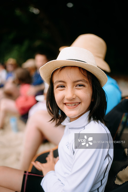 在海滩营地对着镜头微笑的可爱女孩图片素材